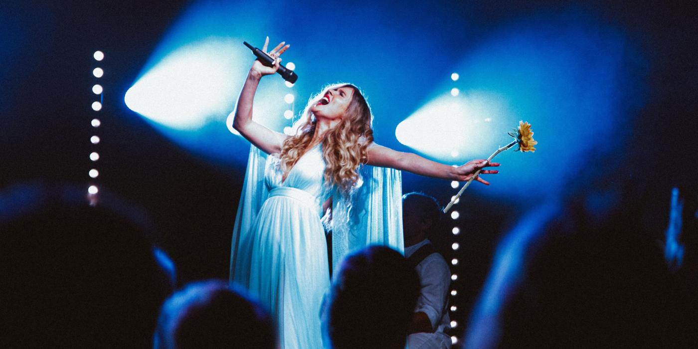 Joss Stone belting on stage holding a flower