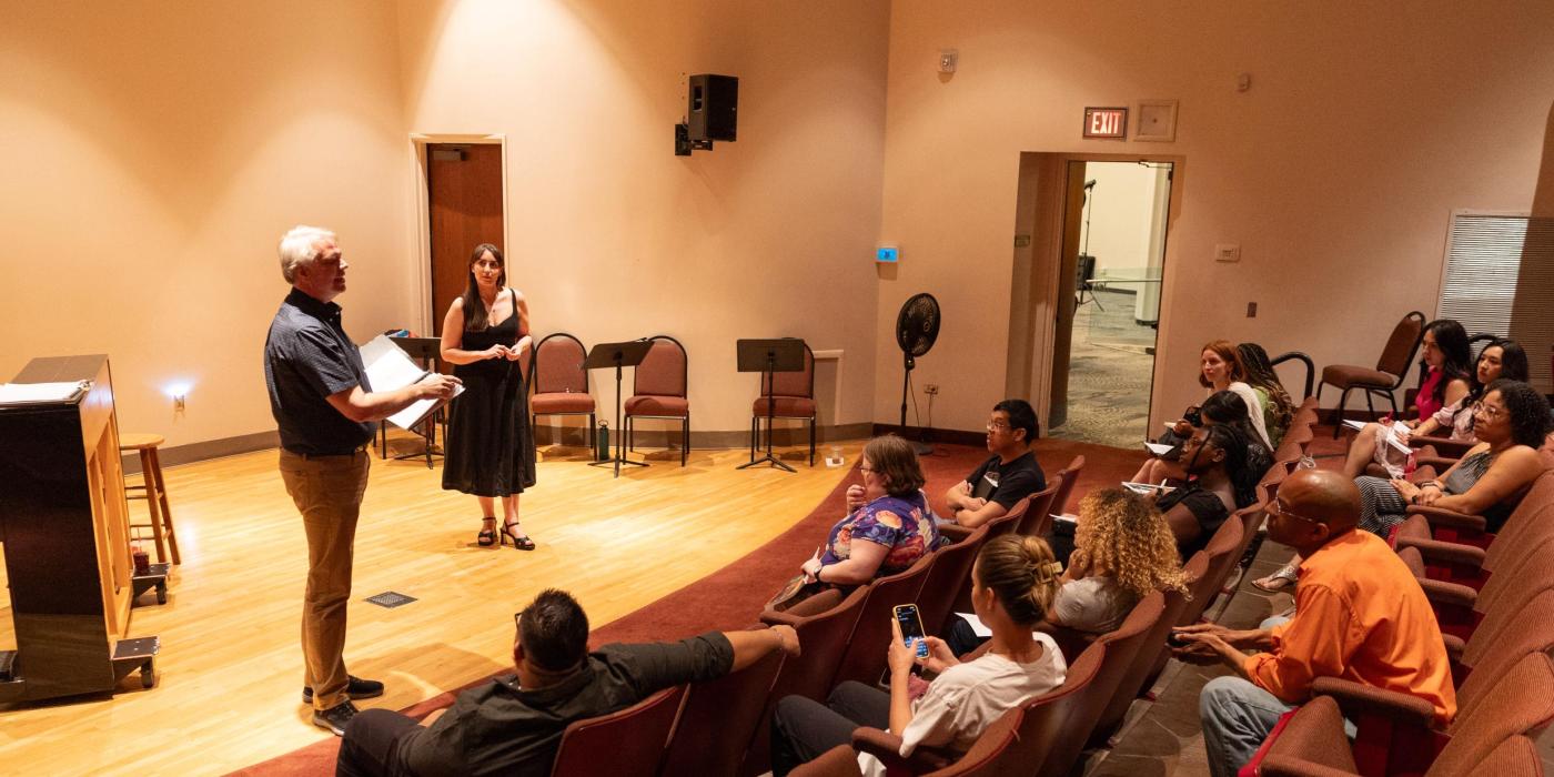 students looking at two presenters in a small theatre