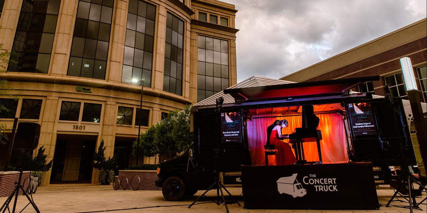 Concert truck in plaza with pianist on stage 