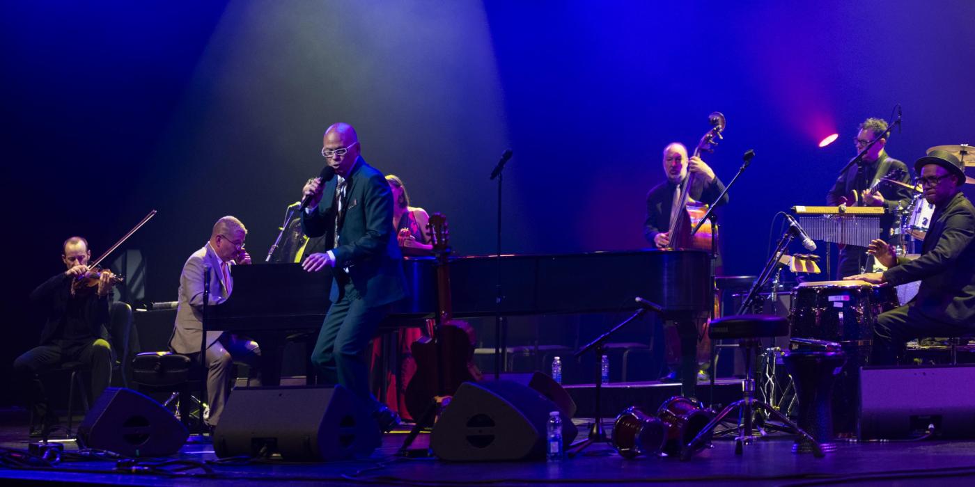 Band of musician on stage with vocalist in foreground
