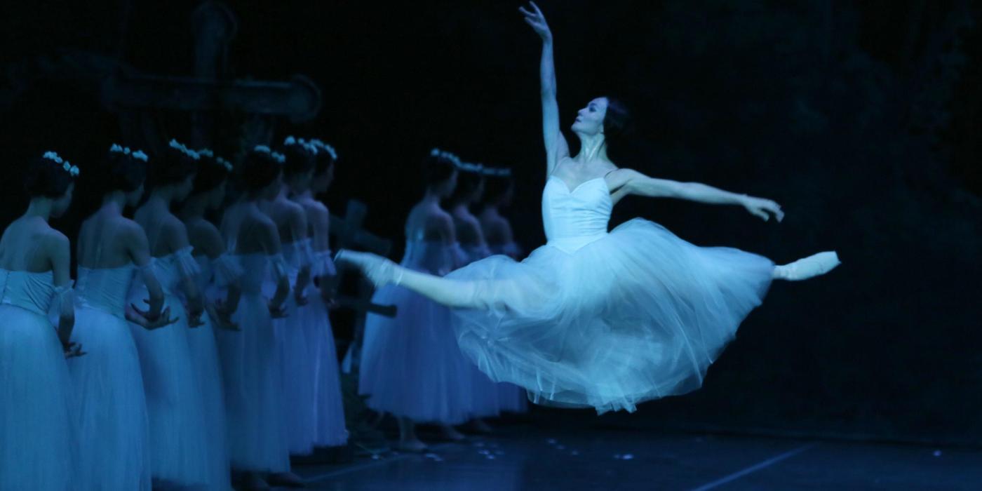 Women ballerina in mid-air splits.