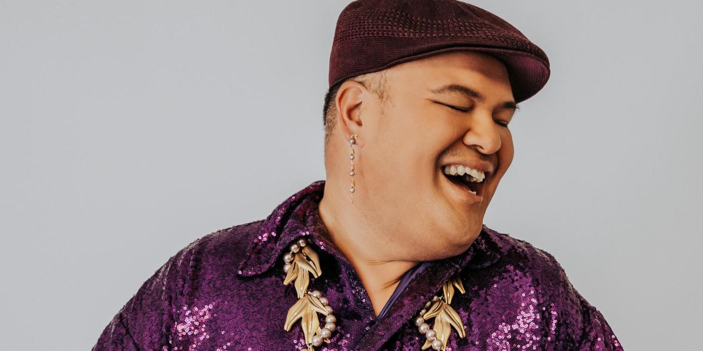 Polynesian male wearing a brown golf cap, purple sequins shirt with a beaded lay