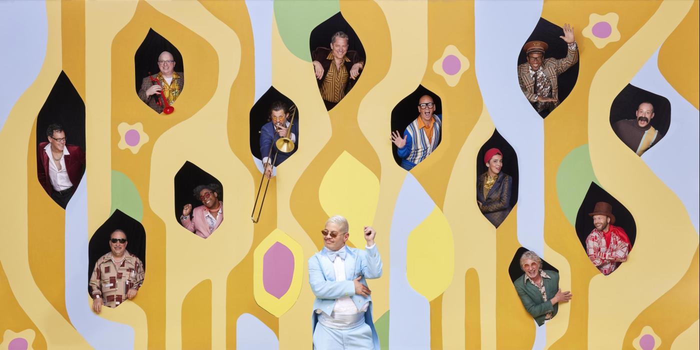 Pink Martini band members in cutouts of retro print wall