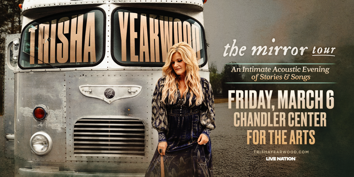 Blonde woman standing in front of silver van/bus