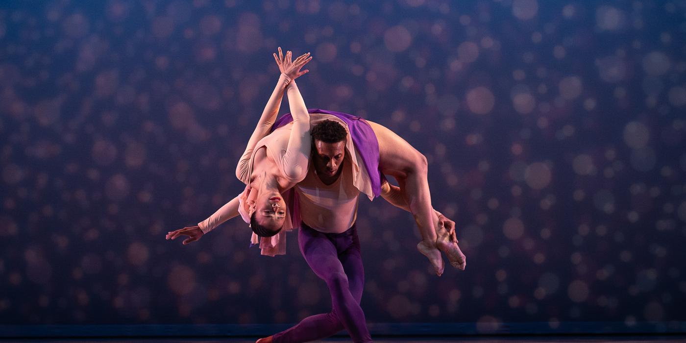 dancer stretching her back while on the shoulders of another dancer