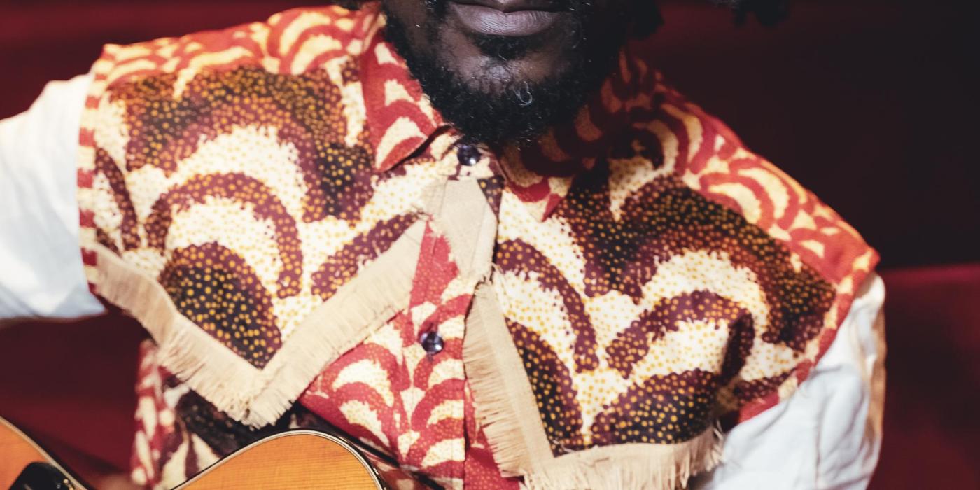 Niwel Tsumbu holding his guitar
