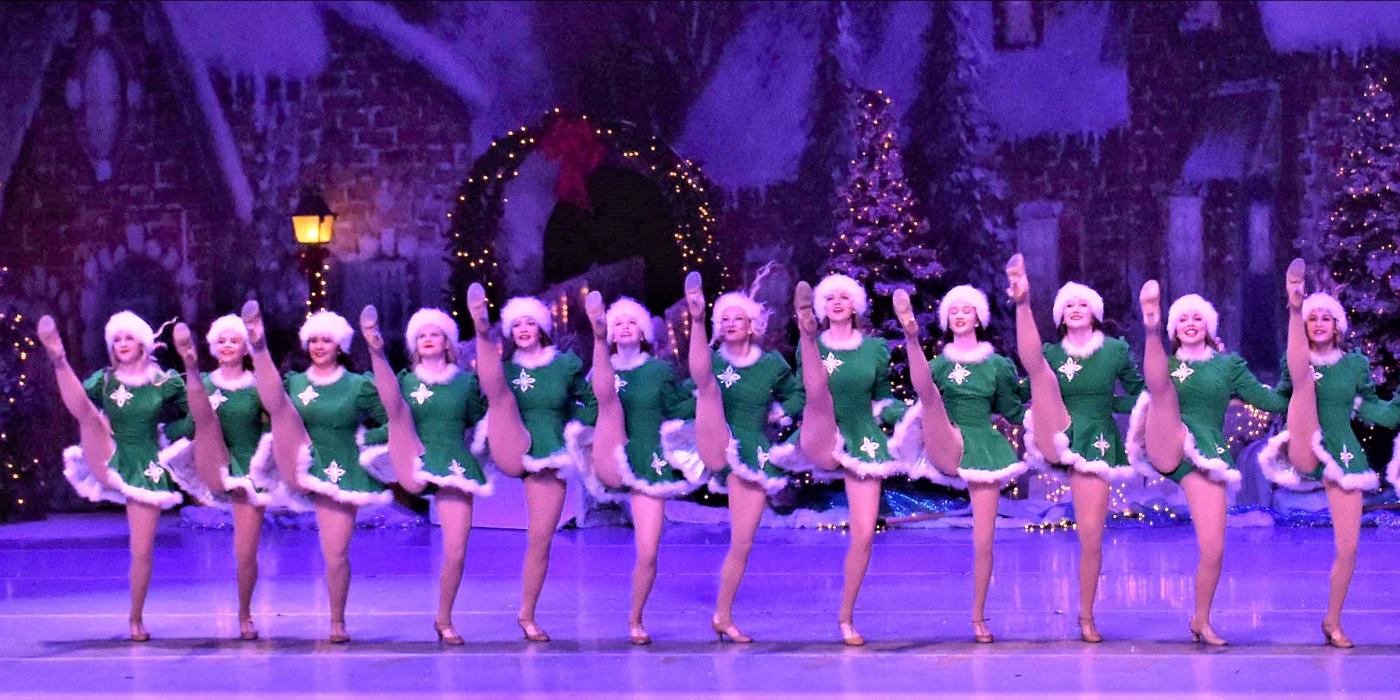 dancers kicking their legs up in a line