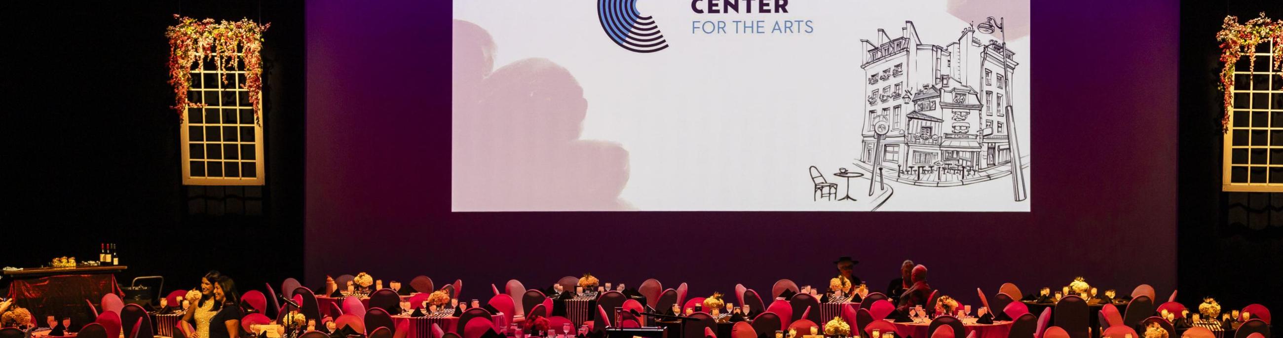 Round tables on top of the mainstage, decorated for a fundraising event