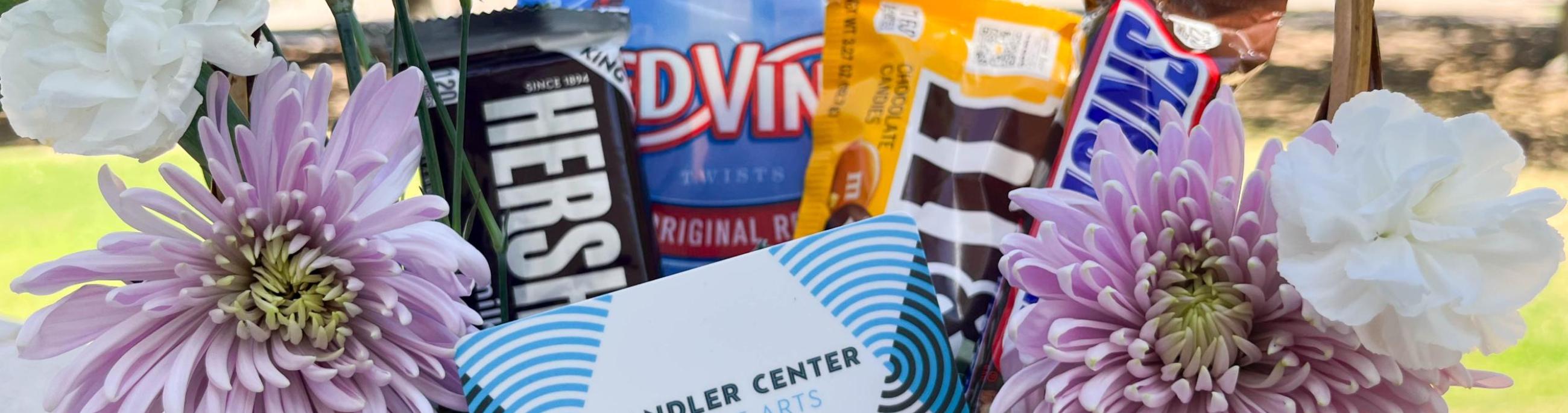CCA gift card sitting in a basket along with flowers and candy.