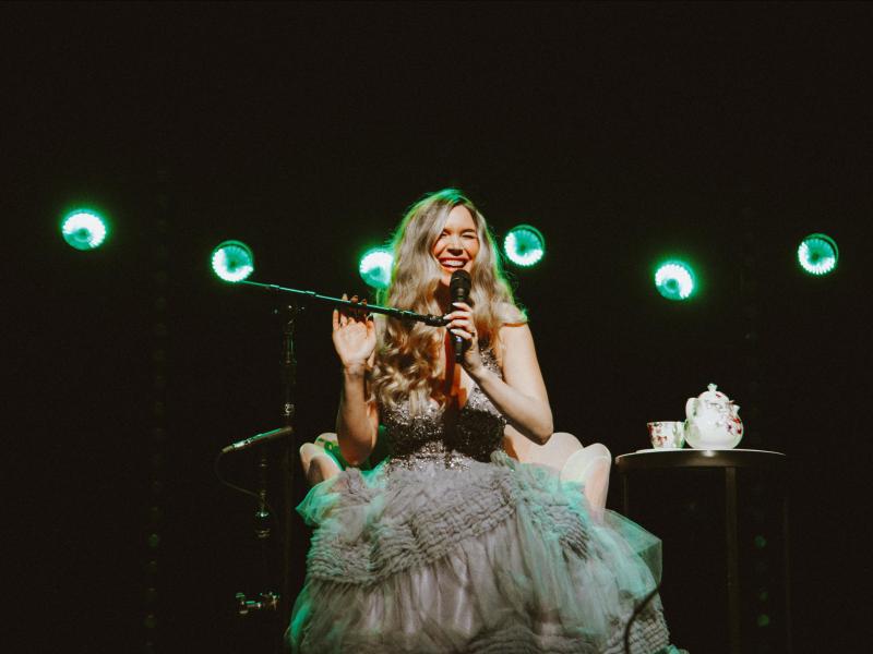Joss Stone sitting on stage singing into microphone