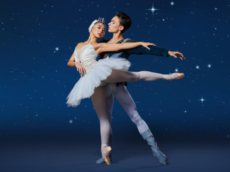 two ballerinas embracing against the night sky