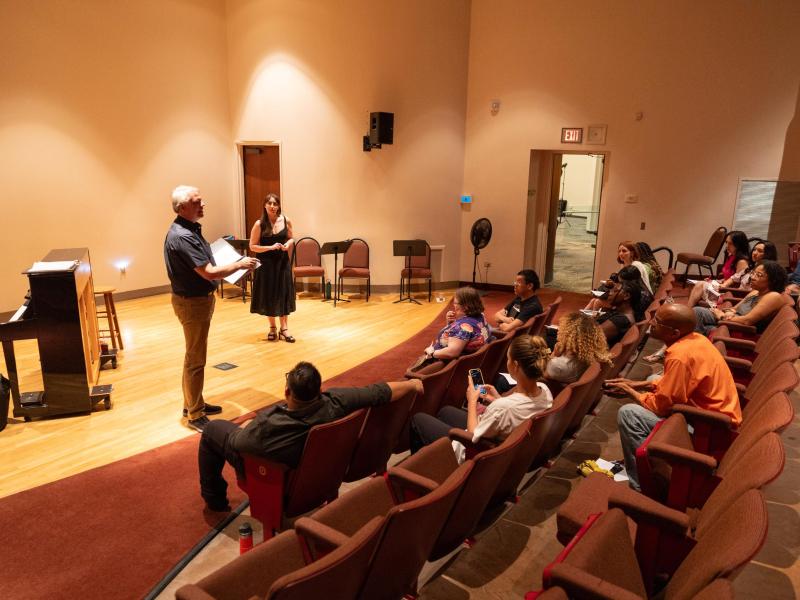 students looking at two presenters in a small theatre