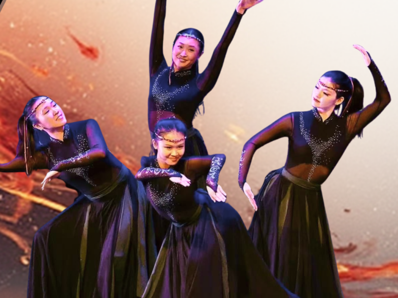 Four Chinese dancers dressed in all black, posing on stage