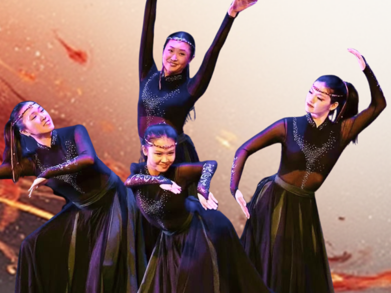 Four Chinese dancers dressed in all black, posing on stage