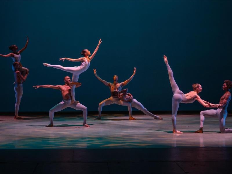 8 dancers, each paired in different poses on stage