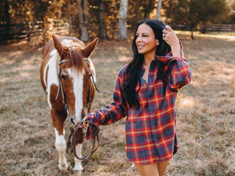 Sara Evans walking a horse outside