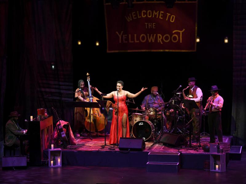 Band on stage with vocalist center, arms raised