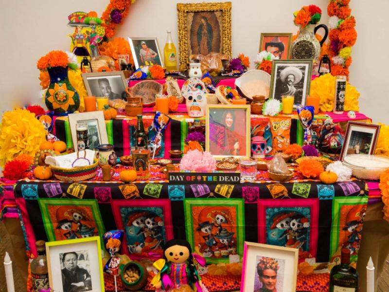 Community altar laden with photos and treats.