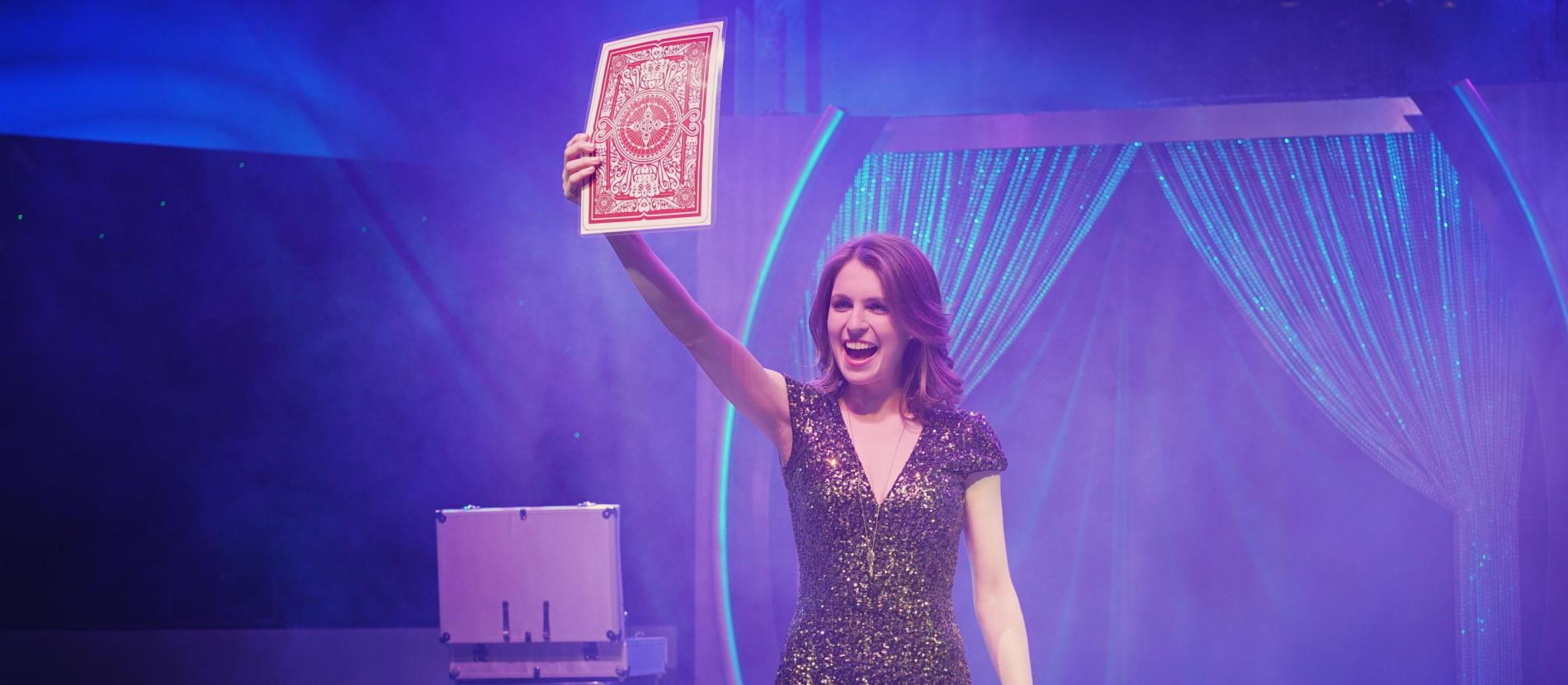 Woman excitedly holding out large playing card