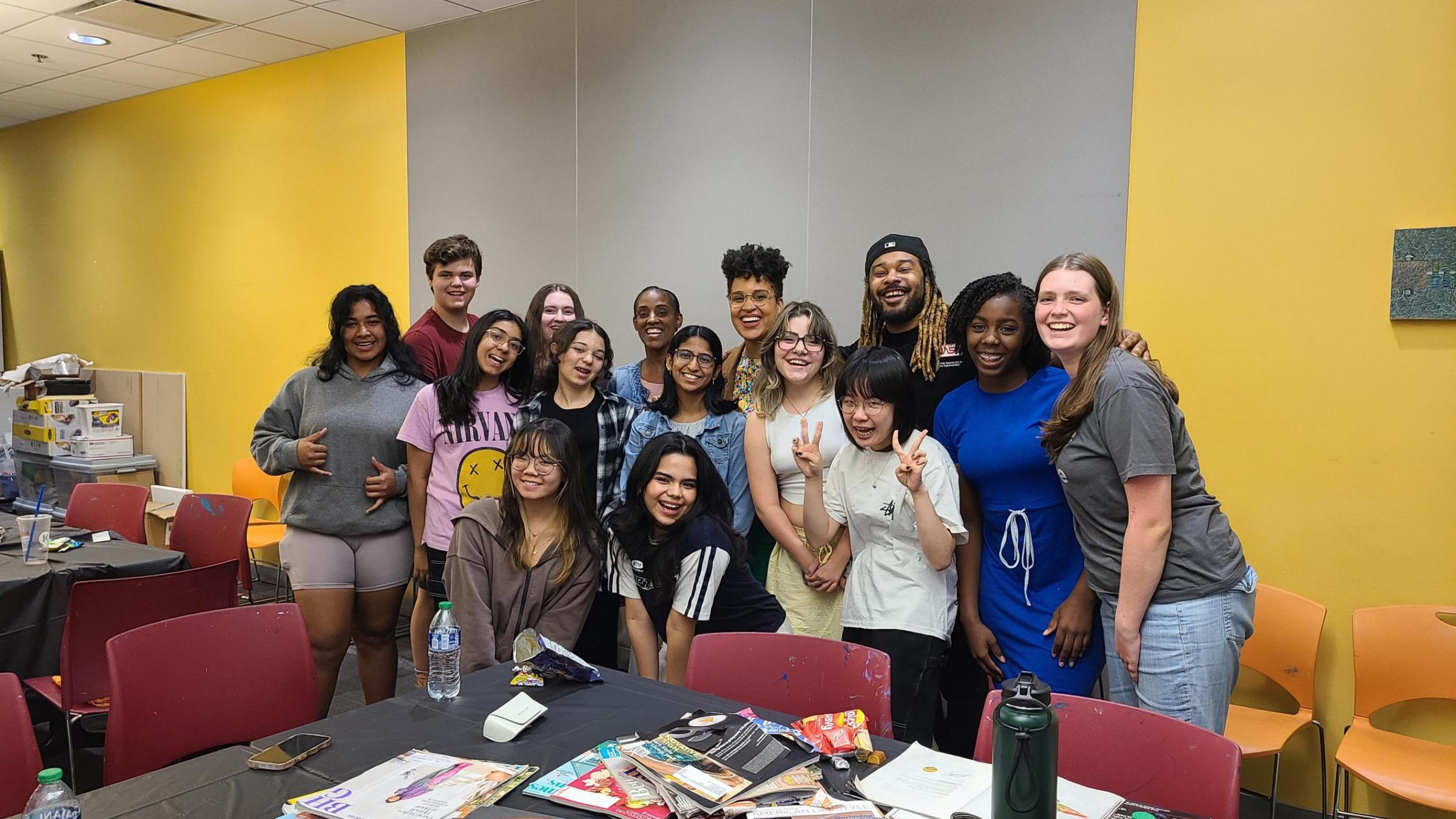 A group of 12 diverse teenagers pose with three adult mentors